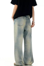 Men’s vintage wash wide leg light-wash denim jeans with faded distressed detailing and a relaxed fit