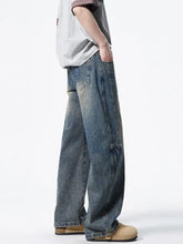 Men’s vintage wash wide leg jeans in faded blue denim with visible stitching and patch pockets