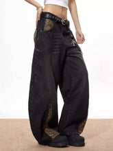 Men’s vintage wide leg black denim jeans with snake print fabric accents on pockets and lower legs and studded belt