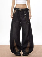 Men’s vintage wide leg black denim jeans with snake print lace side panels and a studded belt with chain accessories