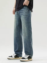 Men’s wash loose fit jeans in blue denim with relaxed straight-leg cut and subtle fading for a casual modern look