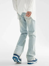 Men’s light-wash denim loose fit jeans with straight-leg cut and subtle fading paired with blue patterned sneakers