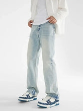 Men’s light-wash loose fit jeans with a straight-leg cut and subtle fading paired with white sneakers with blue accents
