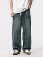 Men’s dark-wash denim relaxed fit jeans with wide-leg cut and white drawstrings at the waist