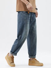 Men’s wash relaxed fit jeans in blue denim with a relaxed fit tapered design and rolled cuffs