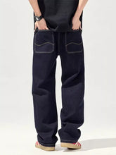 Back side of men’s dark indigo cotton blend relaxed fit jeans with contrasting white stitching on back pockets