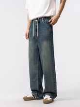 Men’s dark-wash denim relaxed fit jeans with wide-leg cut and elastic waistband with white drawstrings