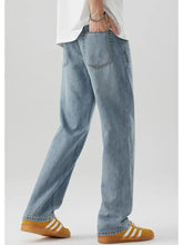 Men’s wash relaxed fit light-wash denim jeans with a relaxed straight-leg cut and classic back pockets shown from the back side
