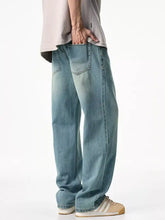 Men’s light-wash denim jeans with a relaxed fit, wide-leg cut, and visible stitching details