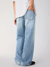 Men’s light-wash denim jeans with wide-leg cut and classic back pockets shown from the back side