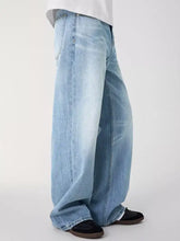 Men’s light-wash denim jeans with a relaxed fit, wide-leg cut, and frayed hems in durable cotton material