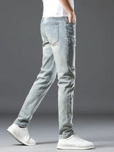 Men’s wash slim fit jeans in light-wash denim showing back side with slim fit and subtle distressing on the back pocket