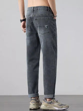 Men’s wash straight leg jeans in dark gray denim with subtle faded wash and embroidered logo on back pocket shown from back