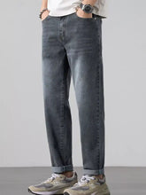 Men’s dark-wash denim straight leg jeans with a relaxed fit and rolled cuffs visible from the front side