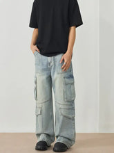 Men’s light-wash denim cargo jeans featuring multiple large pockets and a relaxed wide leg cargo fit
