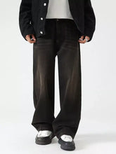 Men’s black wide leg jeans made of denim with a faded distressed wash and visible stitching details