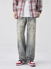 Men’s distressed gray denim wash wide-leg jeans with faded paint splatter and subtle graffiti-style markings