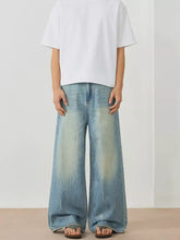 Men’s wide leg jeans in faded light blue denim with a wash and distressed details for casual wear