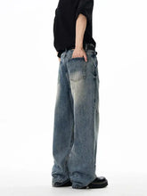 Men’s wash wide leg jeans in faded blue denim with subtle distressing and reinforced stitching for a relaxed fit