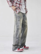 Men’s wash wide-leg jeans in faded denim with distressed details and subtle paint splatter for casual wear