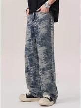 Men’s wash wide leg jeans featuring wide-leg denim with a faded distressed blue and gray camouflage pattern