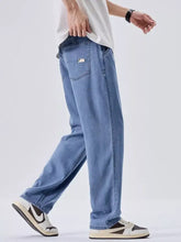 Men’s wash wide leg jeans in light-wash blue denim with a relaxed straight-leg cut and a back pocket patch visible from the back