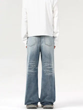 Men’s light-wash denim wash wide leg jeans with distressed ripped knees and a relaxed fit wide leg cut