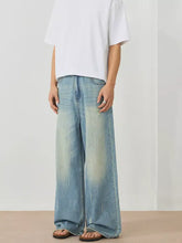 Men’s light-wash denim wide leg jeans with faded distressed look and subtle whiskering for casual wear