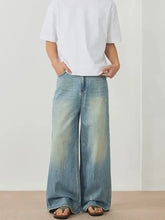 Men’s light-wash denim wide leg jeans with faded distressed look and frayed hems for casual wear
