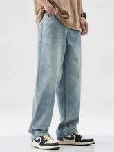 Men’s wash wide leg jeans in light-wash denim with slight stretch and subtle distressed details in a relaxed fit
