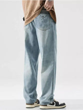 Men’s wash wide leg jeans in light-wash denim with slight stretch and subtle distressing on the back pocket view of back side