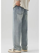 Men’s wash wide leg jeans in light-wash denim with a relaxed straight-leg cut and classic back pockets shown from the back