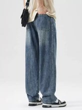 Men’s wash wide leg jeans showing rear view in medium-wash blue denim with classic stitching and rear pockets