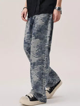 Men’s wash wide leg jeans featuring wide leg denim pants with a faded distressed blue and gray camouflage pattern