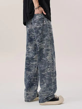 Men’s wash wide leg denim pants with faded distressed camouflage pattern in blue and gray tones