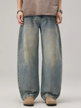 Men’s wash wide leg jeans in faded blue denim with intentional distressing and subtle fading for a vintage look