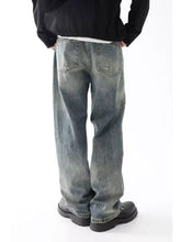 Men’s washed denim wide leg relaxed fit jeans with a faded distressed look and classic back pockets shown from the back