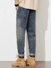 Men’s washed loose fit blue denim jeans with rolled cuffs and subtle fading in casual style