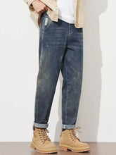 Men’s washed loose fit jeans in dark-wash denim with a relaxed fit and rolled cuffs for casual wear