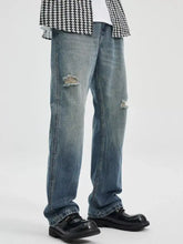 Men’s washed ripped bootcut jeans in blue denim with distressed intentional rips at the knees