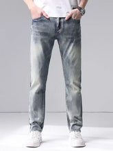 Men’s washed slim fit jeans in light-wash denim with faded distressing along the thighs