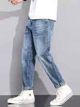 Men’s light-wash denim straight leg jeans with a relaxed fit and rolled cuffs
