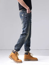 Men’s dark-wash denim jeans with a faded distressed look and classic stitching in a washed straight leg cut