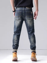 Men’s dark-wash denim washed straight leg jeans with slim fit, subtle fading, classic back pockets, and rolled cuffs viewed from the back