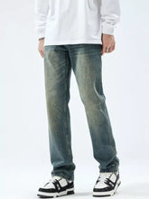 Men’s washed straight leg jeans in distressed medium-wash denim with faded worn areas and a straight leg cut
