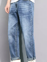 Men’s light-wash denim straight leg jeans with relaxed fit and rolled cuffs in a washed straight leg style