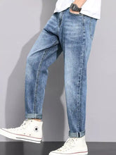 Men’s light-wash denim straight leg jeans with relaxed tapered fit and rolled cuffs for casual wear