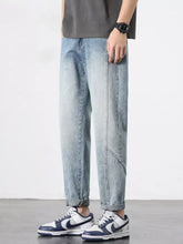 Men’s light-wash denim wide leg jeans with relaxed tapered fit and subtle diagonal stitching details