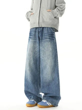 Men’s washed wide leg jeans in faded blue denim with subtle distressing and a relaxed straight cut silhouette