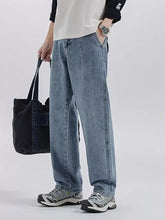 Men’s washed wide leg jeans in light-wash denim with a relaxed straight-leg cut and visible seam stitching